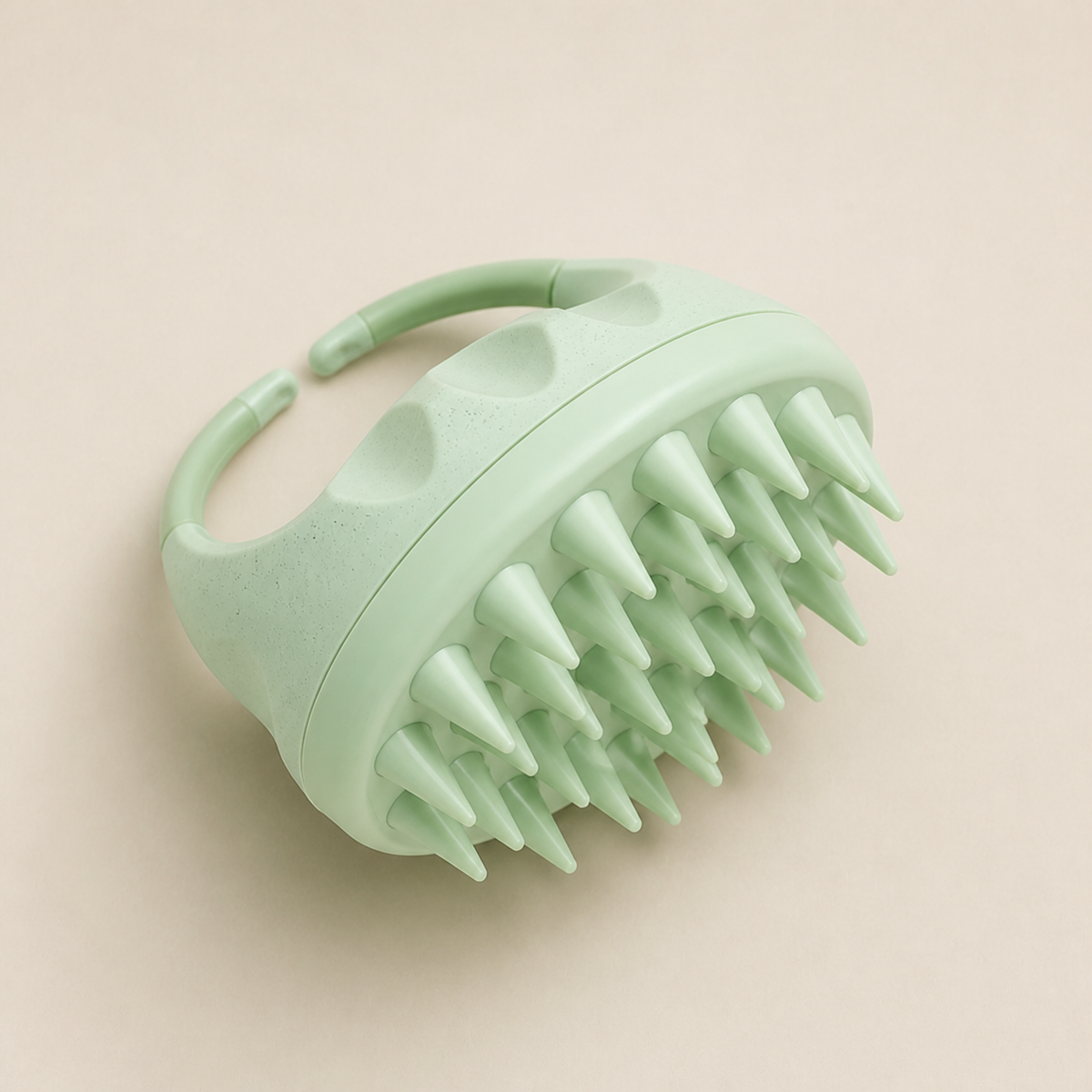 Mint silicone scalp massager showing the bristles and finger strap
